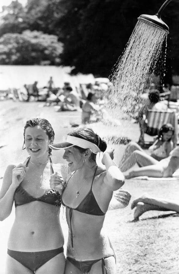 Twop women cool off under a outside shower