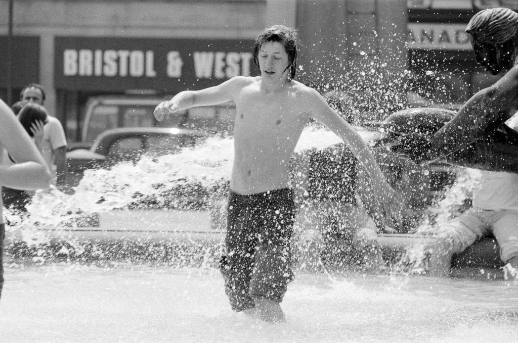 People use fountains to keep cool at Trafalgar Square, London, 8th June 1976.