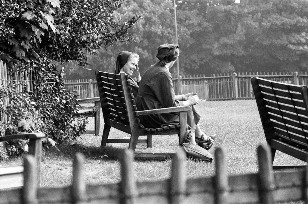 Two nuns sit enjoying the weather, London, 1976.