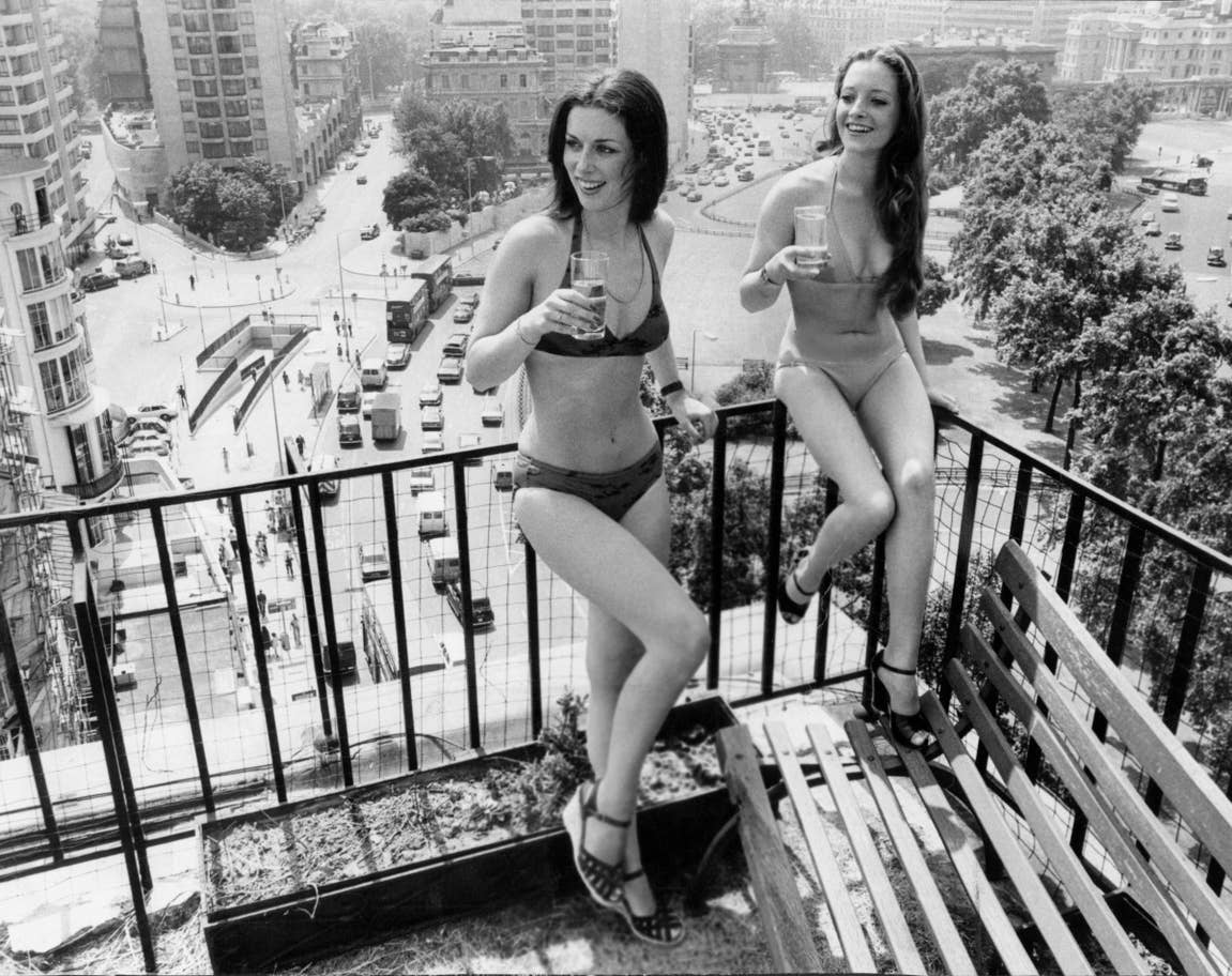 Két nő élvezi a háztetőkre néző kilátást és a hőhullámot