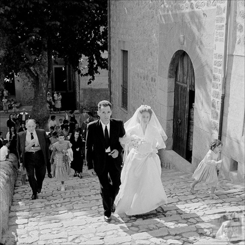 Man accompanying a bride with people in the background, 1956