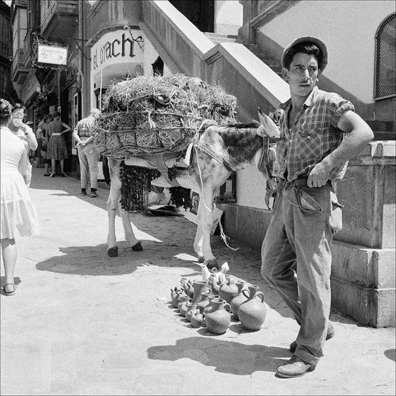 Man selling pots with handle at the back, 1956