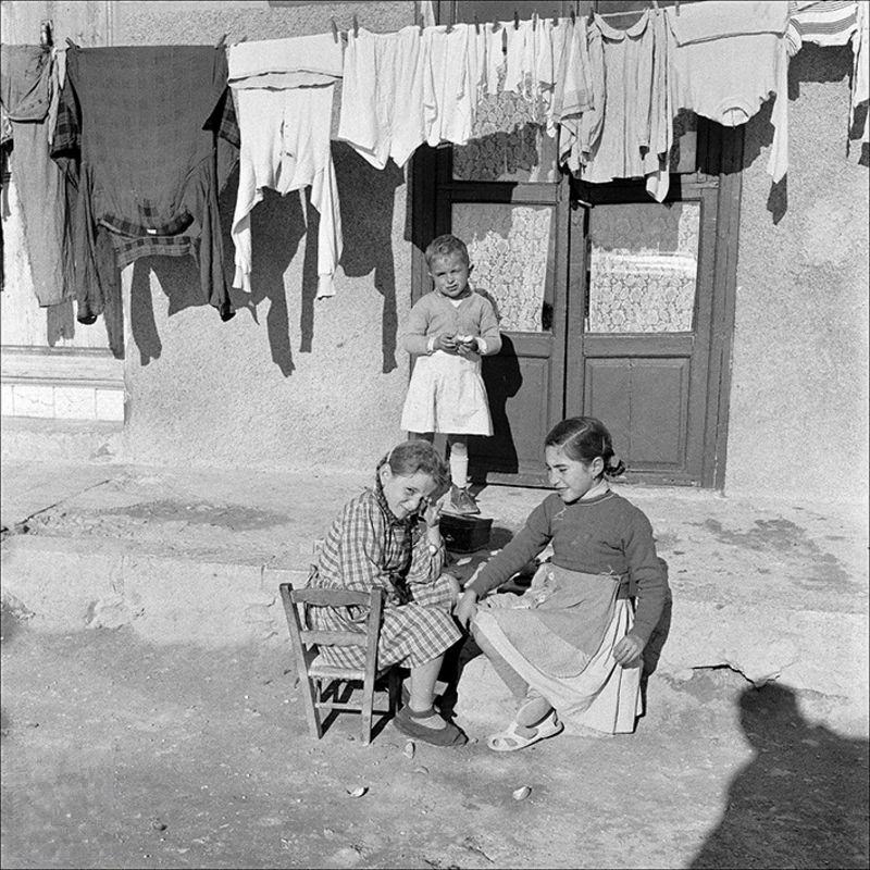 Children with clothes hanging in the background, 1956