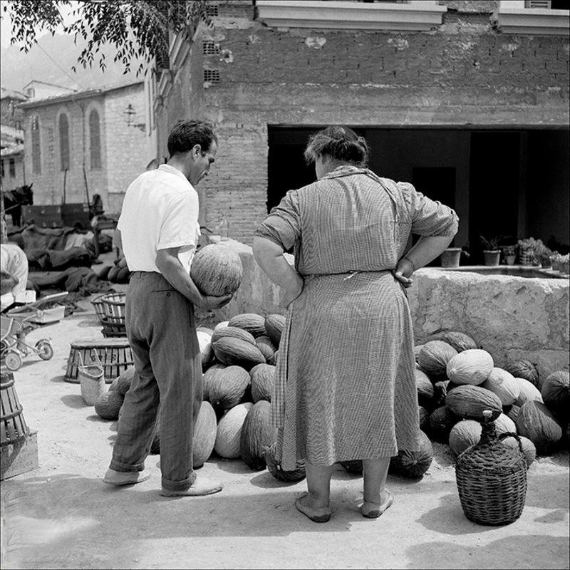 Man and woman in a stall of melons, 1956