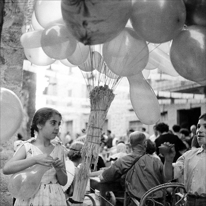 Portrait of a little girl with balloons on the street, 1957