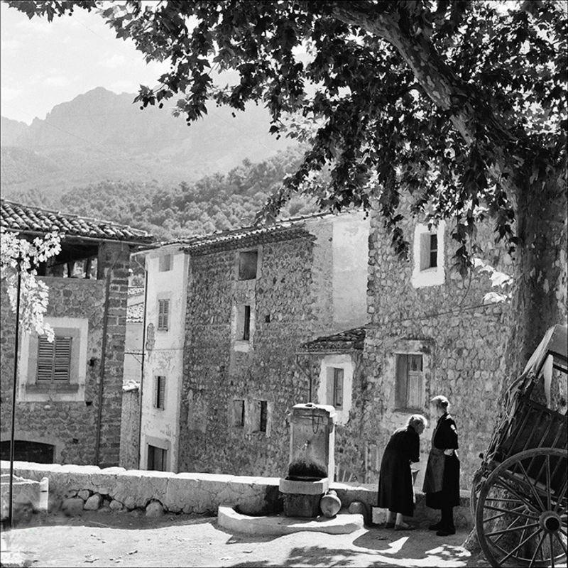 Two women picking up water in a Fornalutx square, 1957