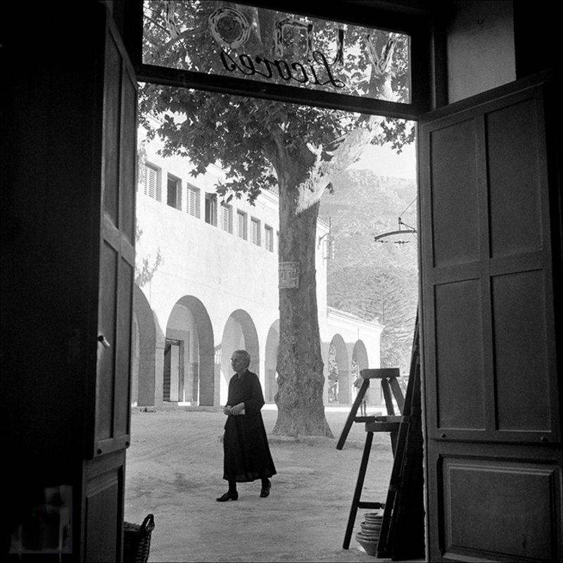 Lady walking from the inside of a wine shop, 1956