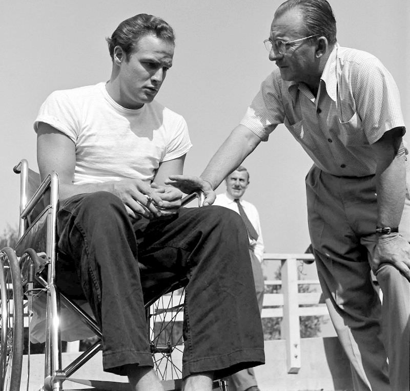 Marlon Brando chats with a production manager while training for his role in 'The Men,' 1949.