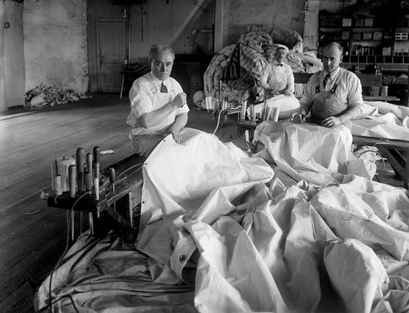 Three sail makers seated at work at Briggs & Beckmans’ Sail Loft, 1915