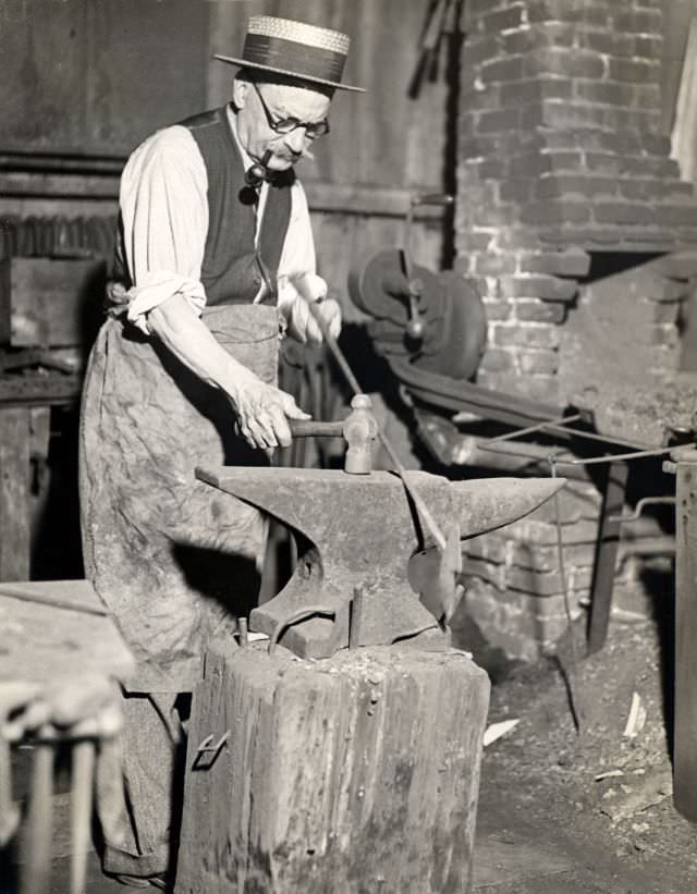 Edward R. Cole, last of the shipsmiths, maker of whalecraft, at the old forge in Fairhaven, New Bedford, 1910s