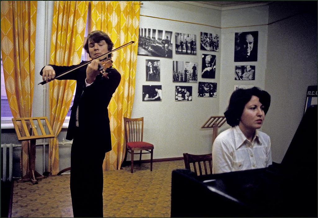 One of the outstanding pupils at the famous Stolyarsky Music School playing on his violin with a piano accompaniment. Photographs of famous ex pupils on the wall.