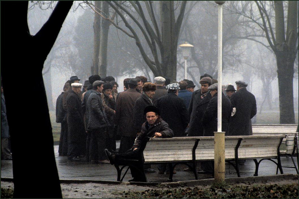 Men gather to talk in the early morning mist and rain in the Shevchenko Park.