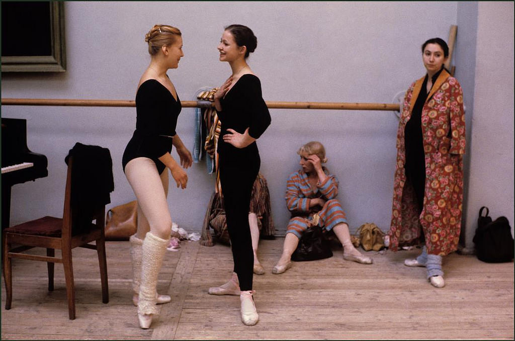 Ballerinas take a break to chat and relax during a break in rehearsals.