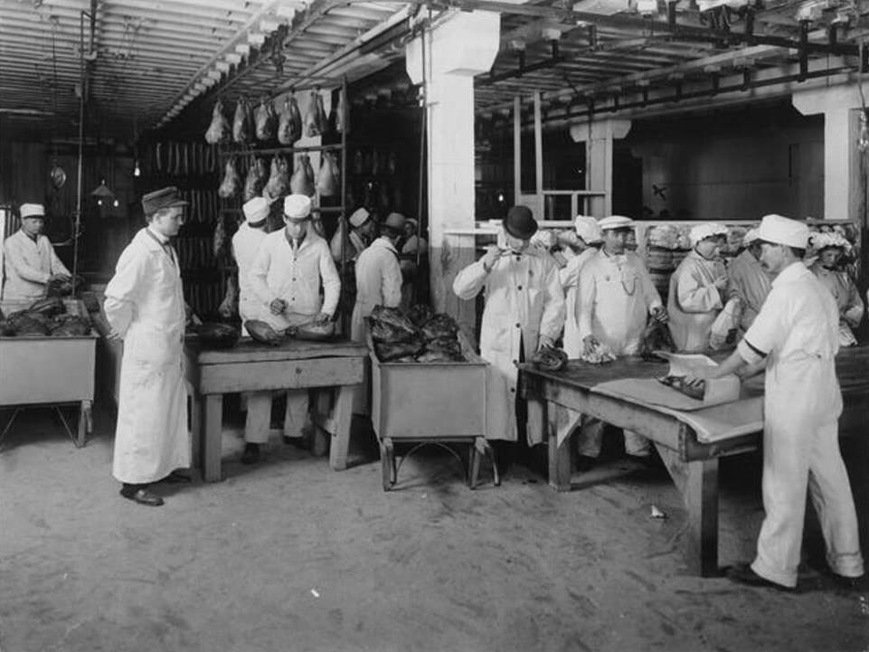 Workers brand smoked hams in a meat packing establishment in South Omaha, Nebraska, 1910.