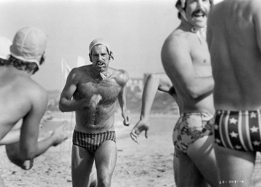 Sam Elliott running on beach in a scene from the film 'Lifeguard', 1976.