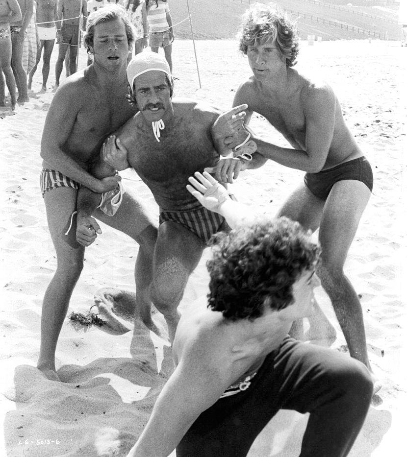 Sam Elliott is held back from beach brawl by Parker Stevenson in a scene from the film 'Lifeguard', 1976.
