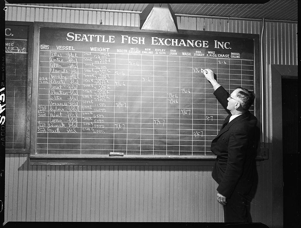 Bill Maddock tracks fish for sale on a blackboard at the Seattle Fish Exchange.