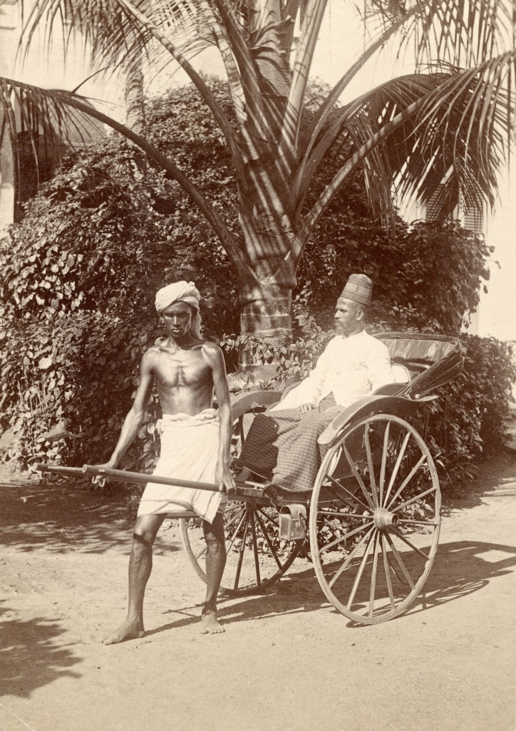 A driver and his passenger in a rickshaw in Kandy, Sri Lanka, 1880s.