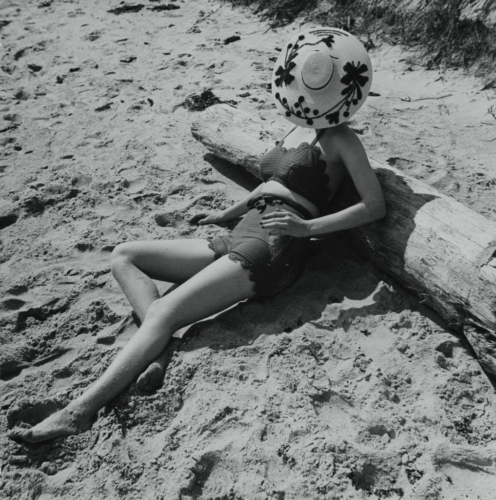 Model, in a dark bra top in a looped crochet and dark knit shorts with ruffled edges, Vogue 1938.