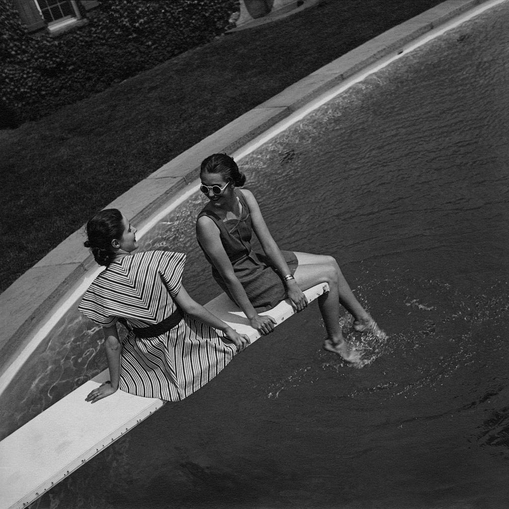 Two models sitting on a diving board, 1936.