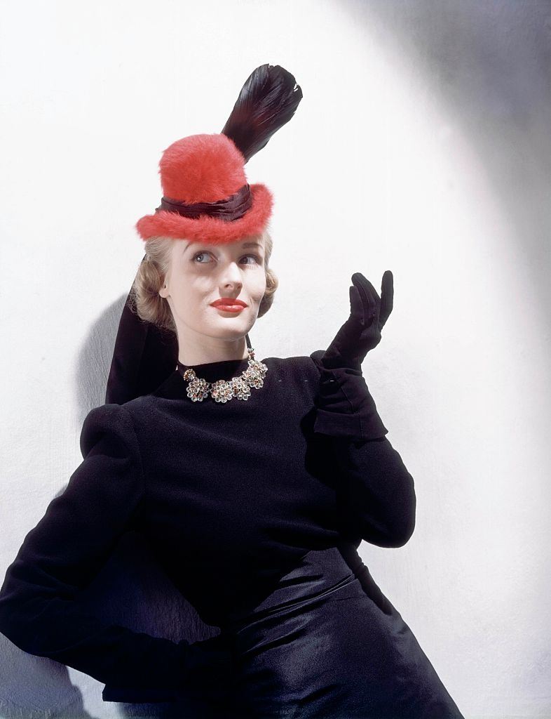 Model wearing red beaver felt hat with broad feather, Vogue 1939.