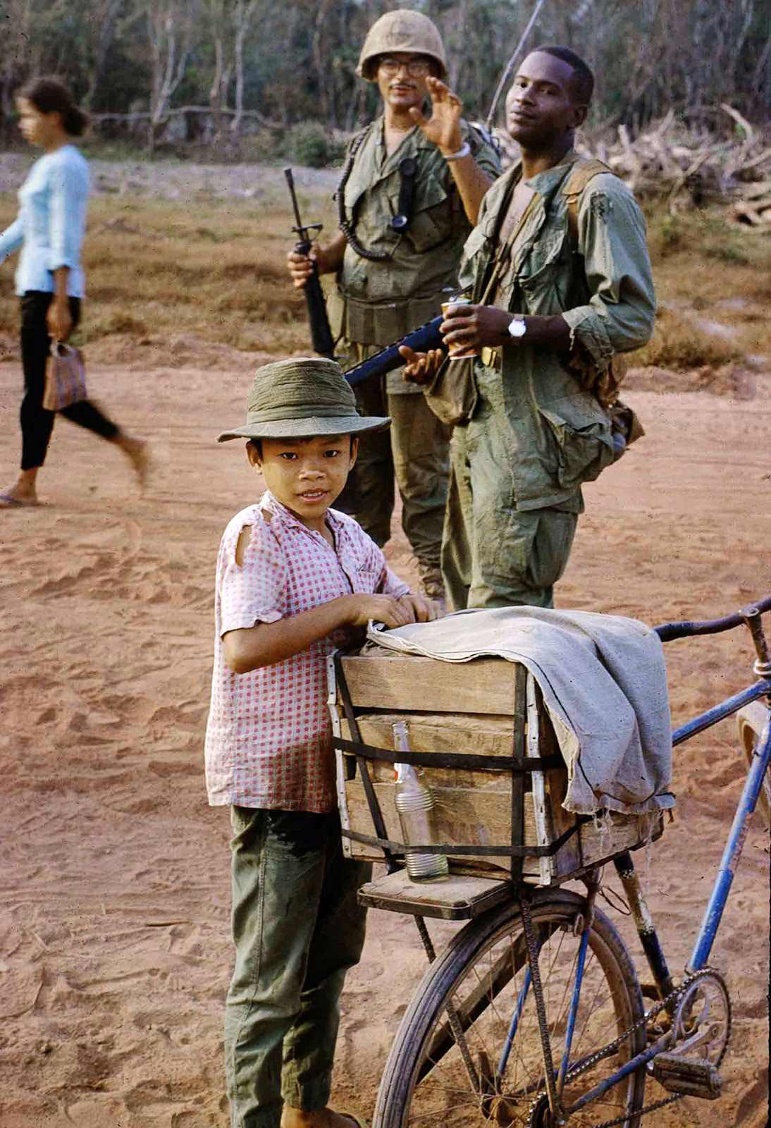 Coke kid and the photographer’s platoon leader, Lieutenant Timor, with his radio telephone operator. Vietnam. February 1969.
