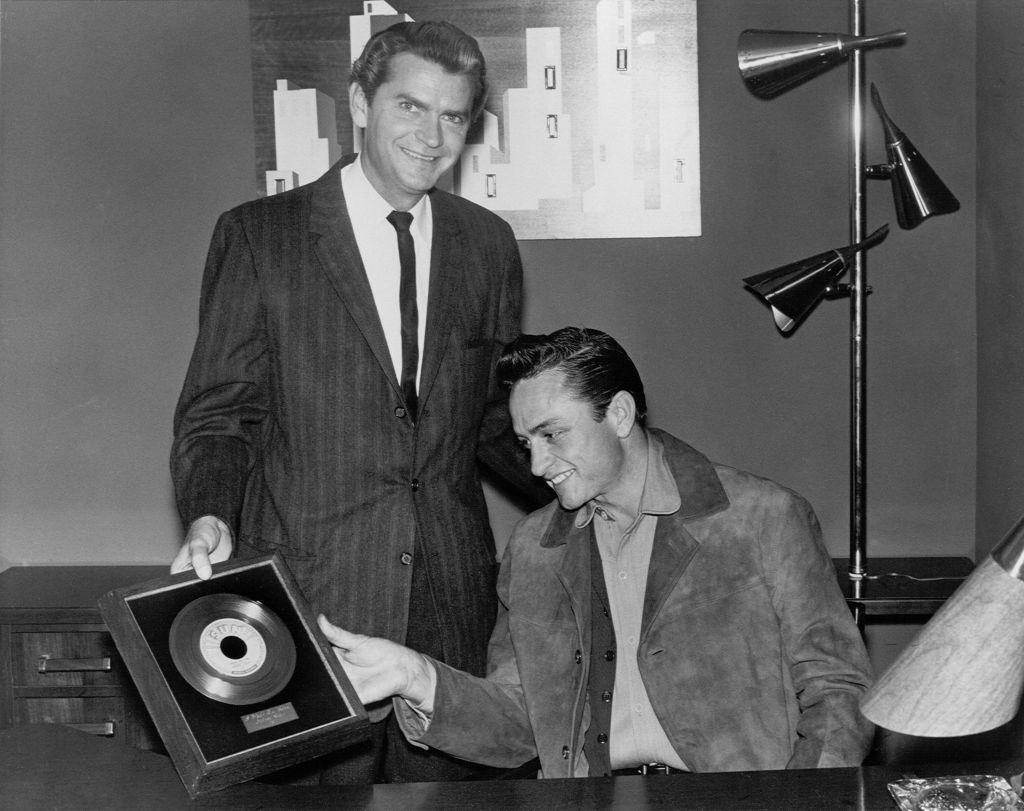Sam Phillips giving a framed record of the song "I Walk The Line" to Johnny Cash, 1956.