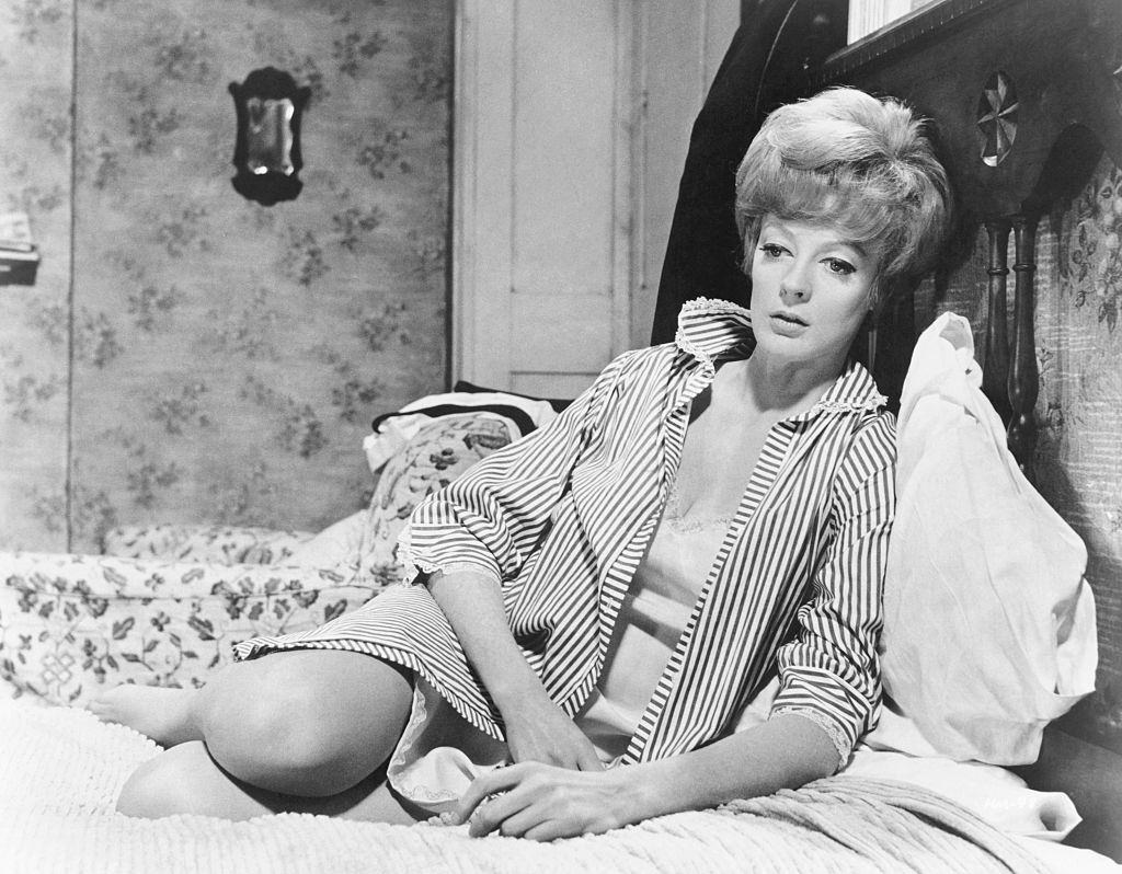 Maggie Smith sits in deep thought on her bed in the 1968 comedy Hot Millions.