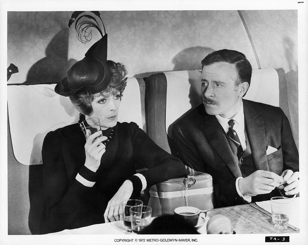 Maggie Smith with Alec McCowen sitting on plane together in a scene from the film 'Travels With My Aunt', 1972.