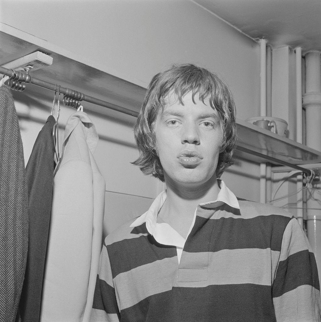 Mick Jagger wearing a rugby jersey backstage on tour in Scotland in early 1964.