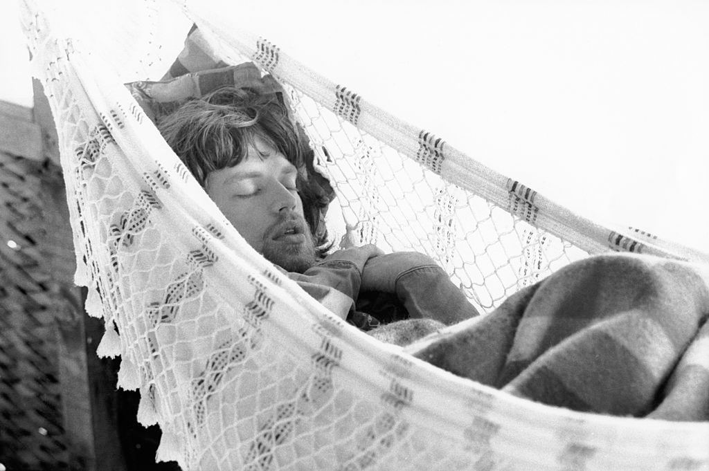 Mick Jagger sleeps in a hammock on the porch of a beach house, Bahia, Brazil, early 1968.