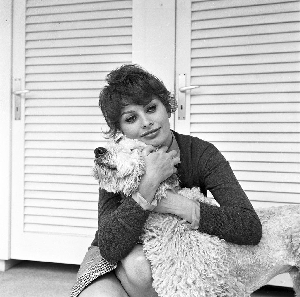 Sophia Loren hugging her dog during a photo shoot in her villa in Burgenstock, 1950s.