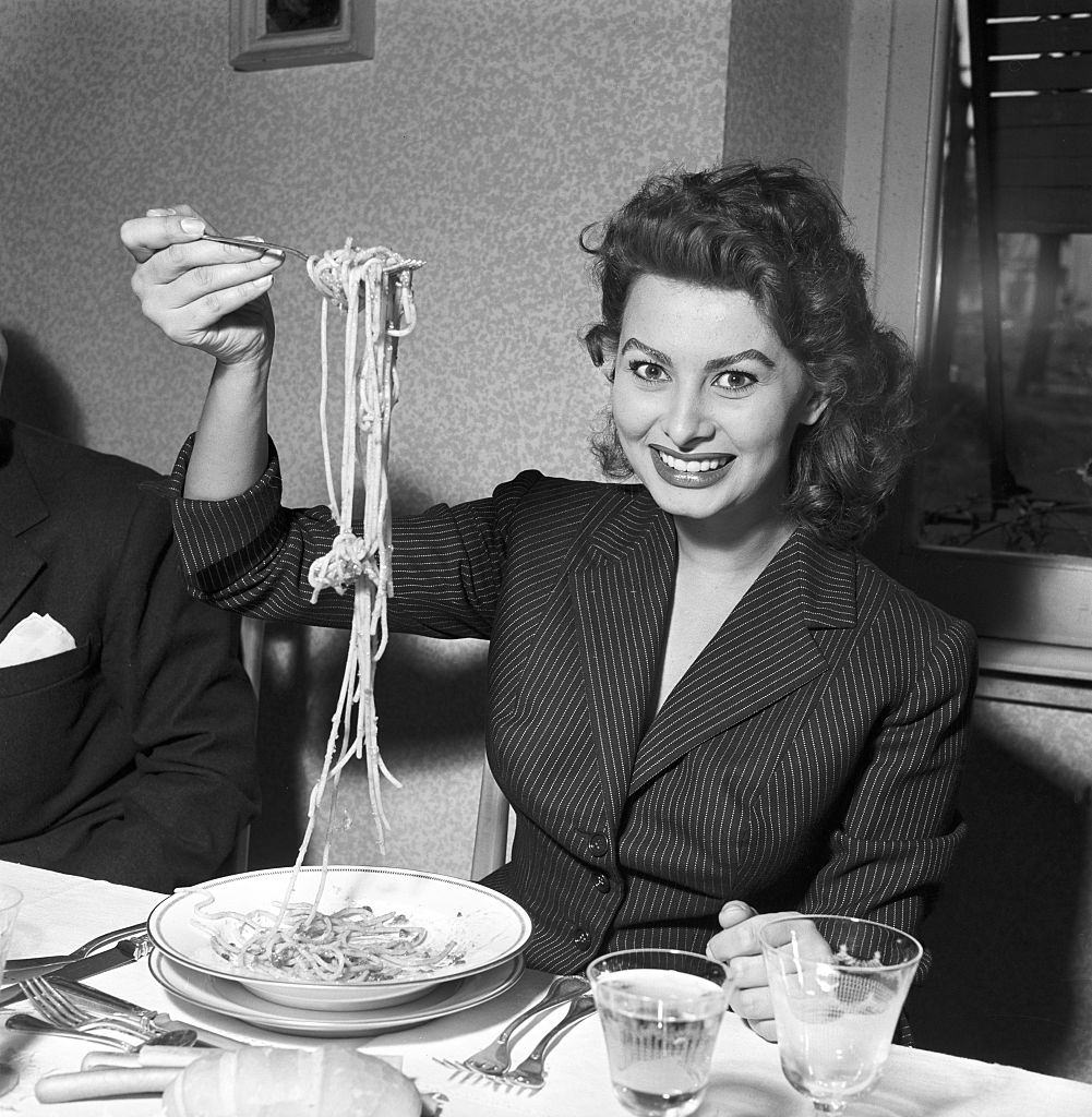 Sophia Loren eating spaghetti in a restaurant, Italy, 1953.