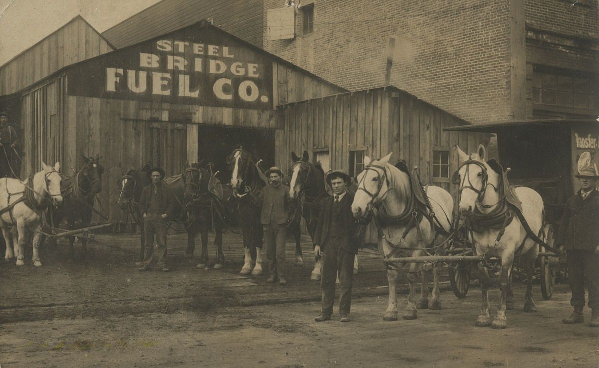 Men and horses in front of the Steel Bridge Fuel Company, circa 1907.