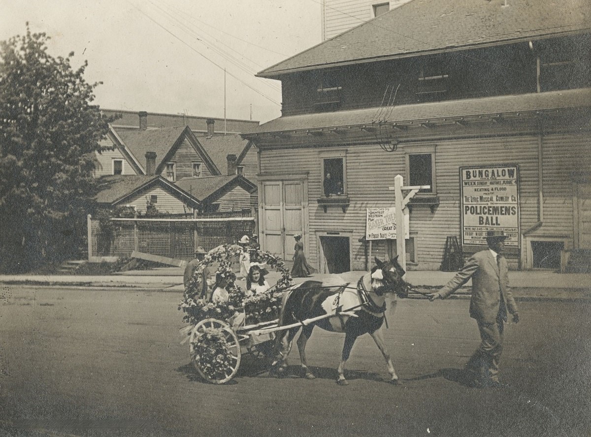 Horse and cart decorated for the Rose Festival on SW 12th Avenue near SW Morrison Street, 1909.