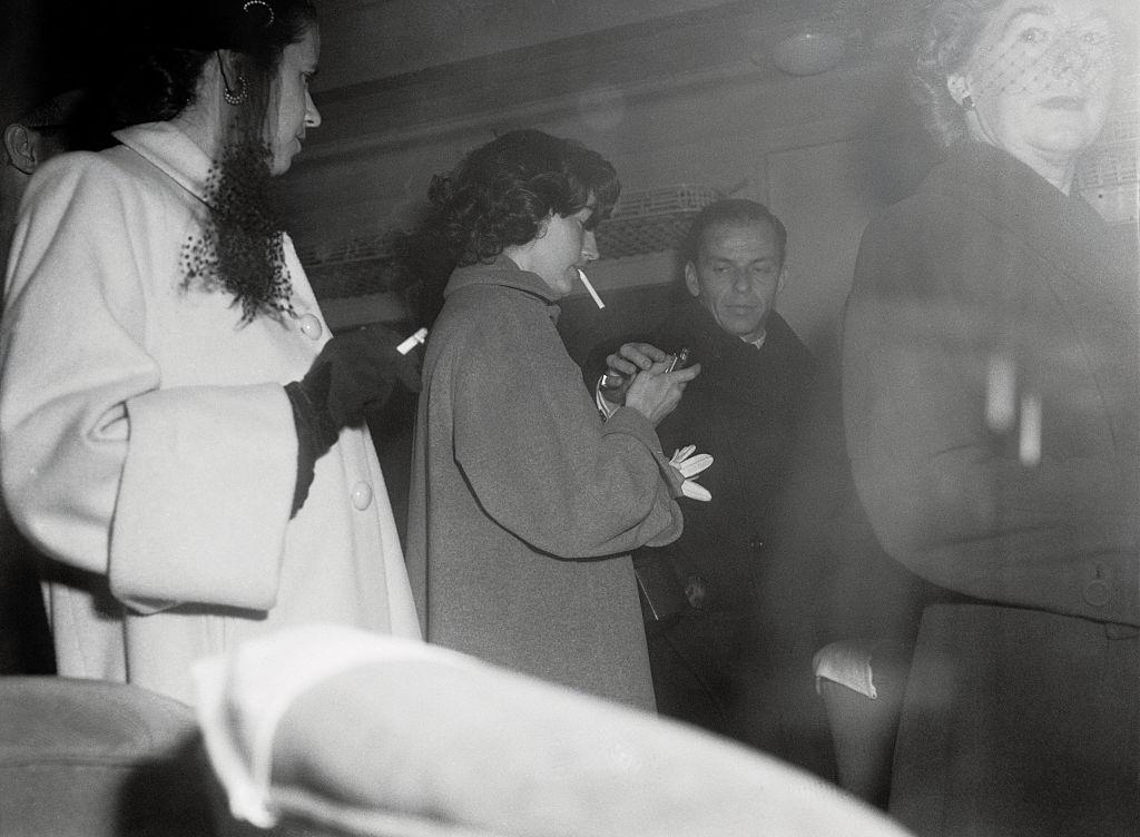 Frank Sinatra assisting Ava Gardner with balky cigarette lighter.