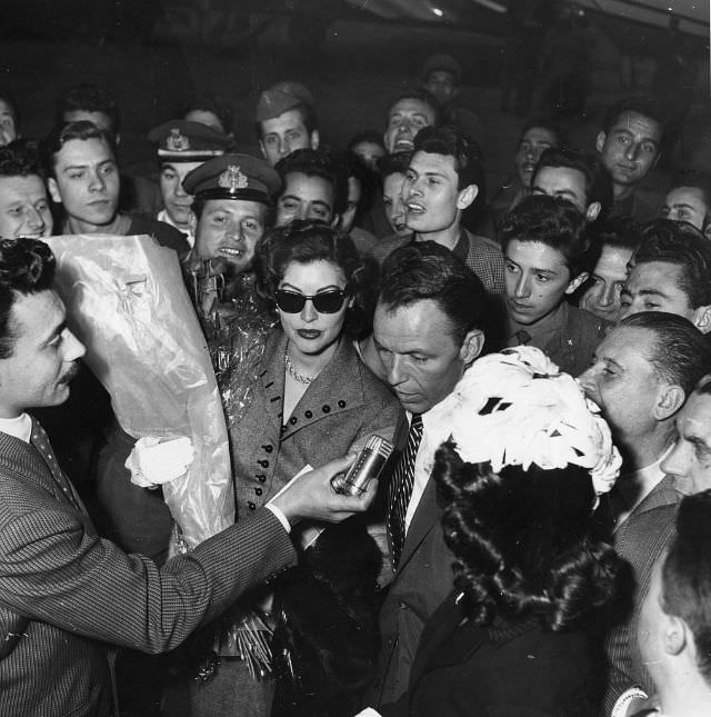 Frank Sinatra and Ava Gardner surrounded by journalists and onlookers, Milan, 1953.