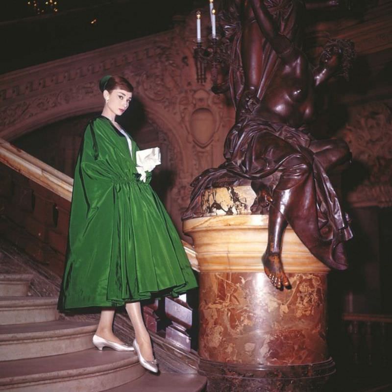 Audrey Hepburn wearing a voluminous evening coat of rustling green taffeta