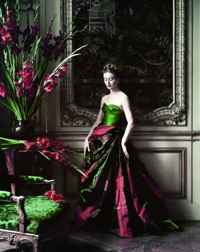 Model Gigi in an evening gown of voluminous plaid taffeta skirt and and green taffeta bustier by Pierre Balmain