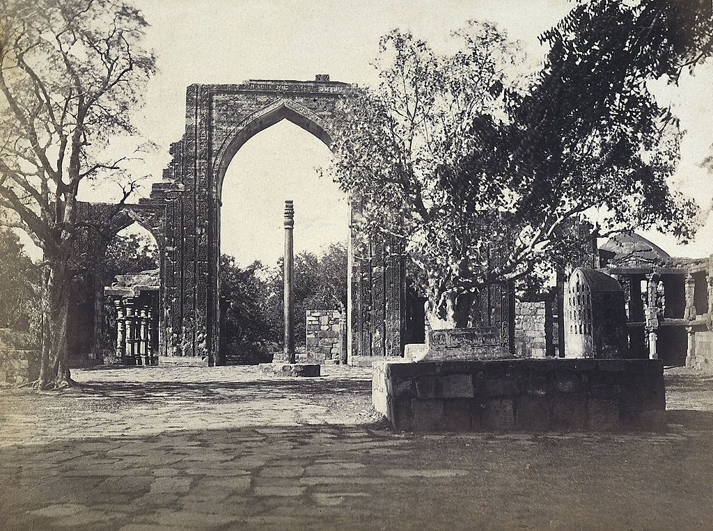 The iron pillar and the great arch of the mosque built by Kutubuddin, near the Qutub Minar, in Delhi, 1870s.