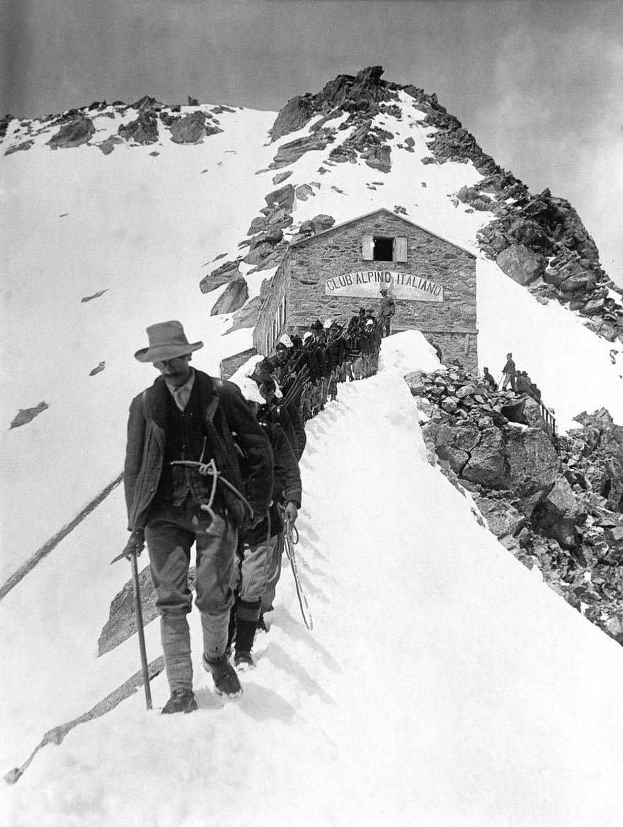 Members of an Italian alpine regiment leave a stone hut high in the Alps. 1915.