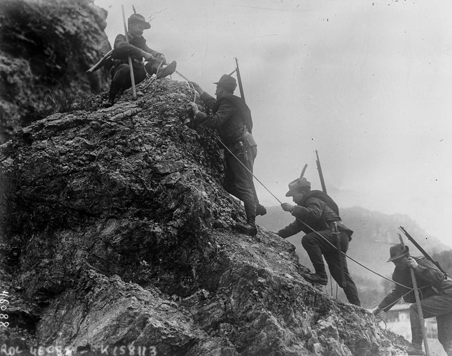 Soldiers lower a wounded comrade down a cliff. 1915.