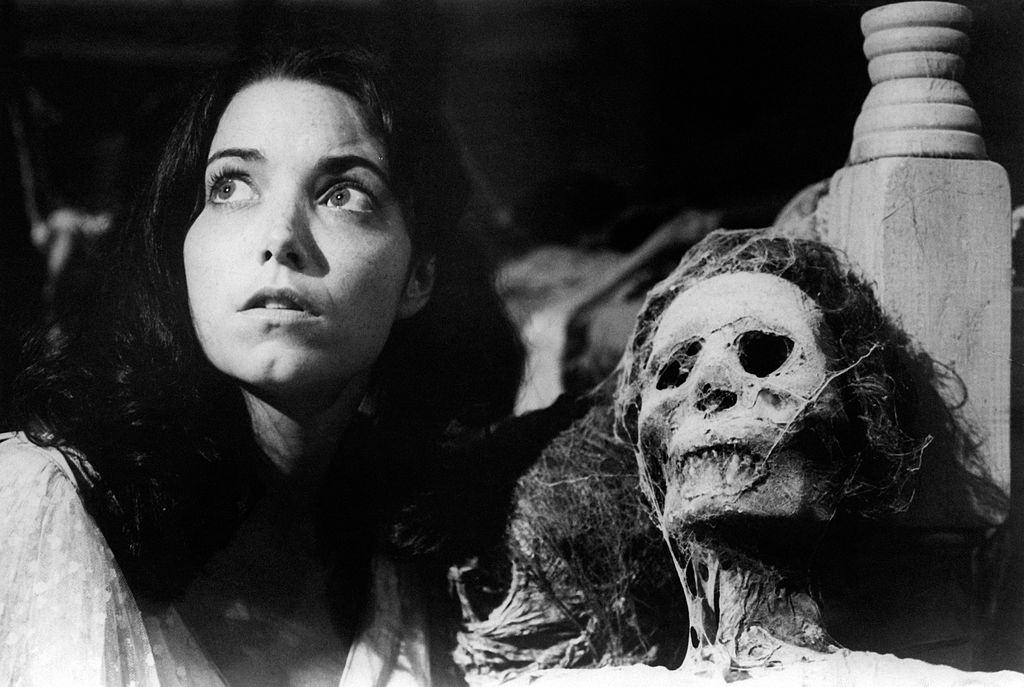 Karen Allen beside a human skeleton in the film Raiders of the Lost Ark. 1981.