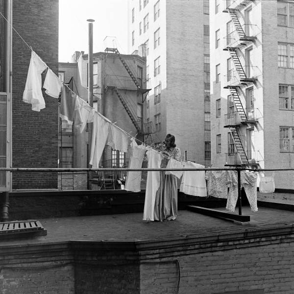 A woman hanging out the laundry on the roof of her building, New York City, 1939.