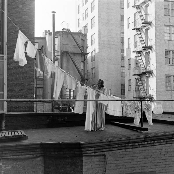 A woman hanging out the laundry on the roof of her building, New York City, 1939.