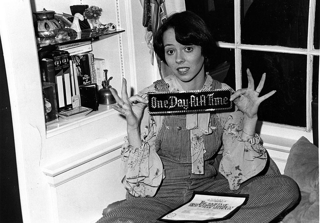 Mackenzie Phillips olding a bumper sticker that reads "One Day At A Time" on December 3, 1976