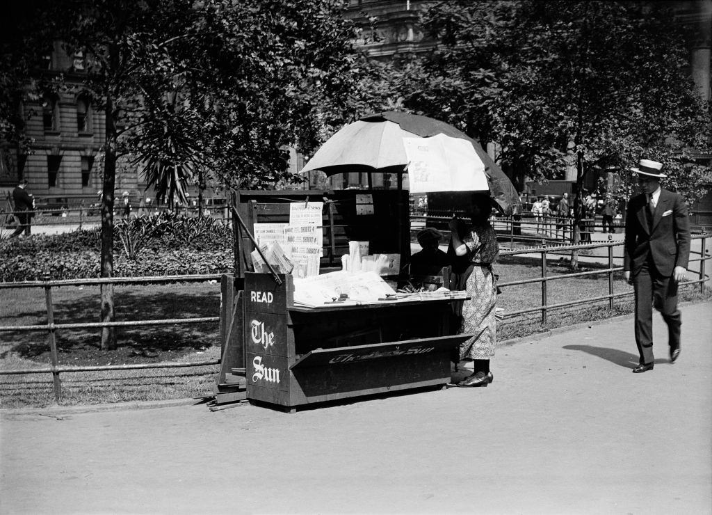 Read the Sun' newspaper stand near City Hall Park, New York City, 1930.
