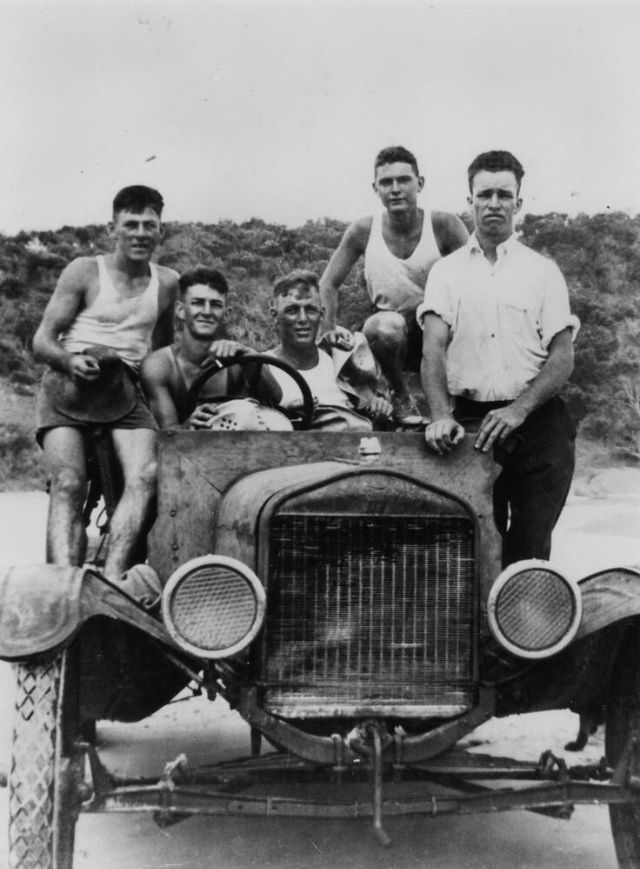 Group of mates riding in a Model T Ford, Double Island Point, Queensland