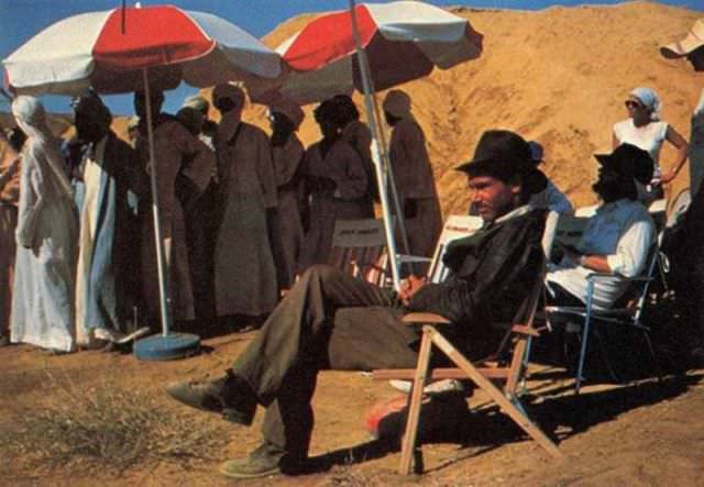 Harrison Ford lounges alongside extras in the desert