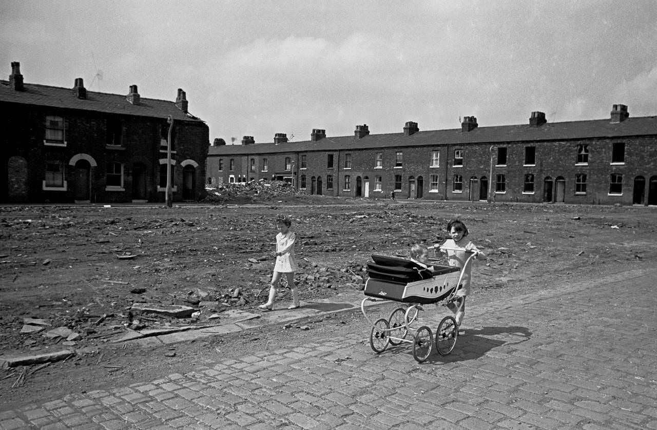 Young girls take baby sister for a walk, Salford 1969
